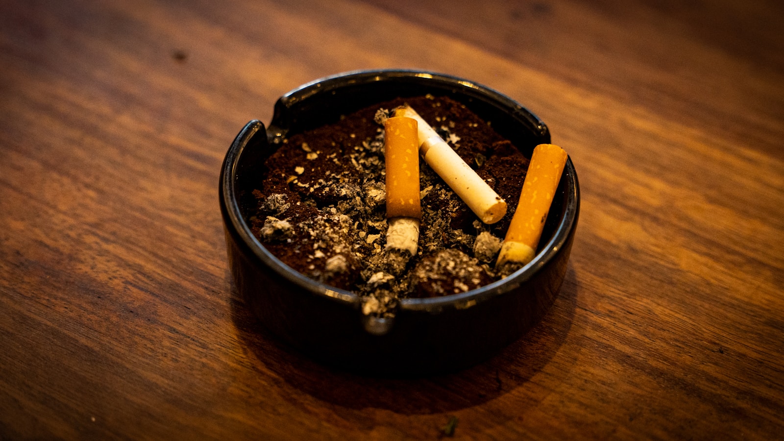 a cigarette holder filled with cigarettes on top of a wooden table